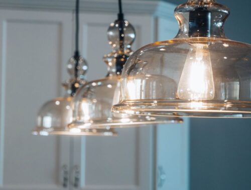Suspension en bronze moderne illuminant un salon élégant avec une décoration raffinée.