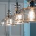 Suspension en bronze moderne illuminant un salon élégant avec une décoration raffinée.