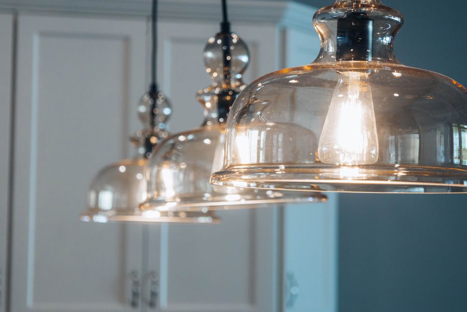 Suspension en bronze moderne illuminant un salon élégant avec une décoration raffinée.